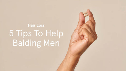 5 tips to help balding men. Image banner shows a close up shot of a hand holding a supplement tablet.