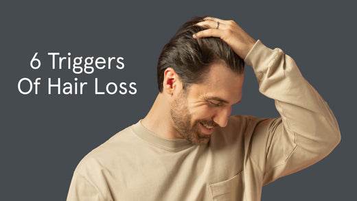 6 triggers of hair loss. On the background is a man using his hand to comb his hair.