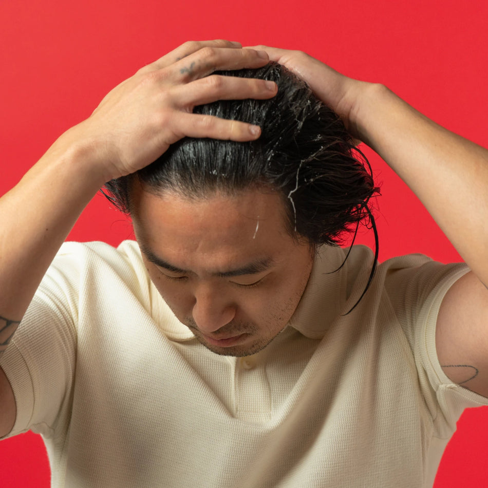 Image showing a man applying conditioner on his hair.