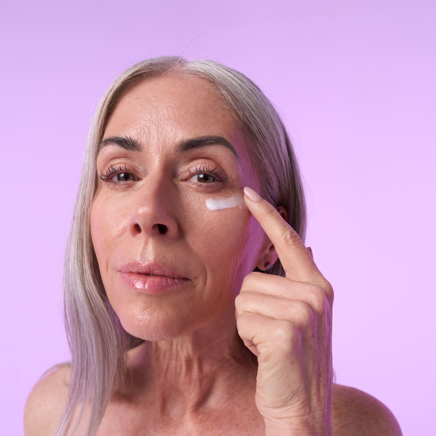 Woman applying cream on her face
