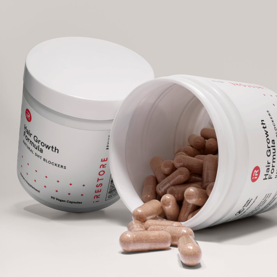 hair growth formula bottle beside and open hair growth formula bottle with tablets falling out