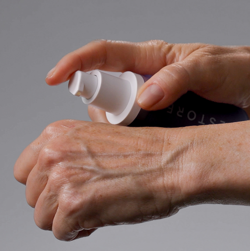 close up of woman applying serum on her hand