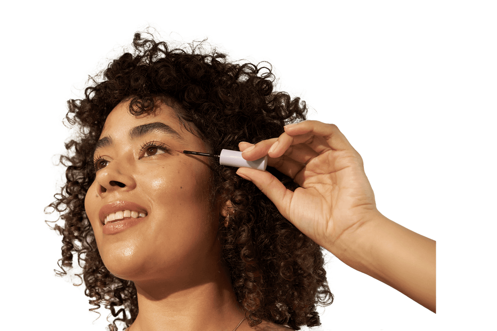 Woman applying eyelash enhancing serum