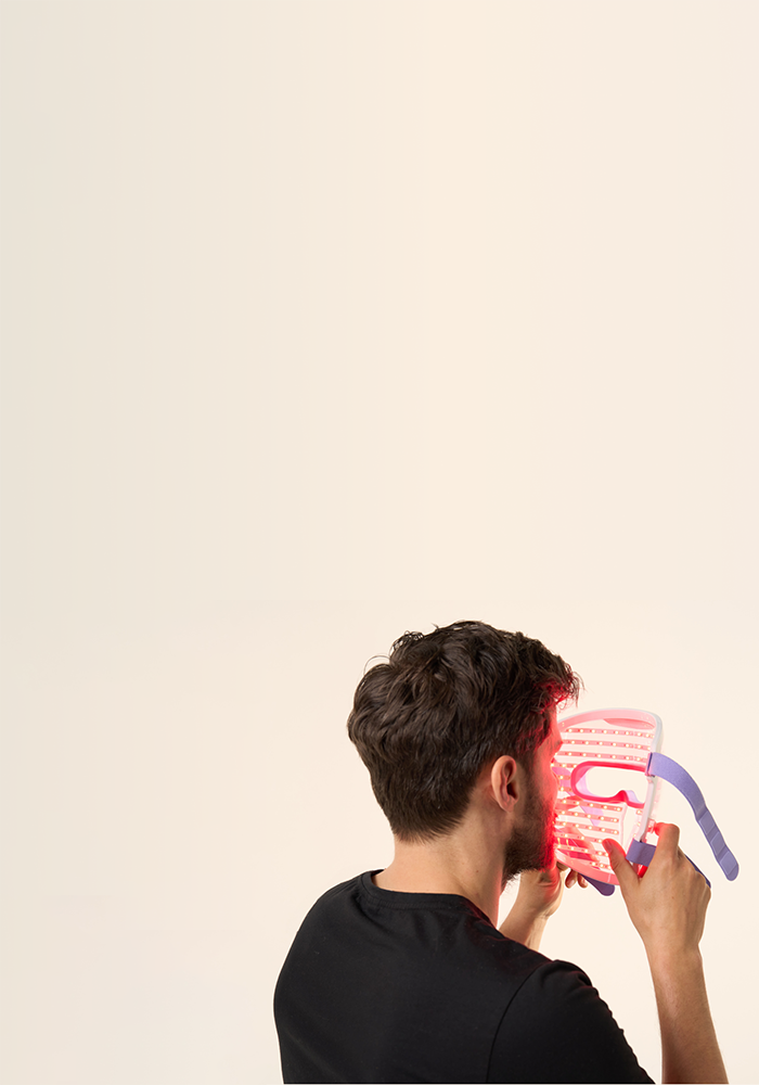 Back view of a man about to wear the LED face mask