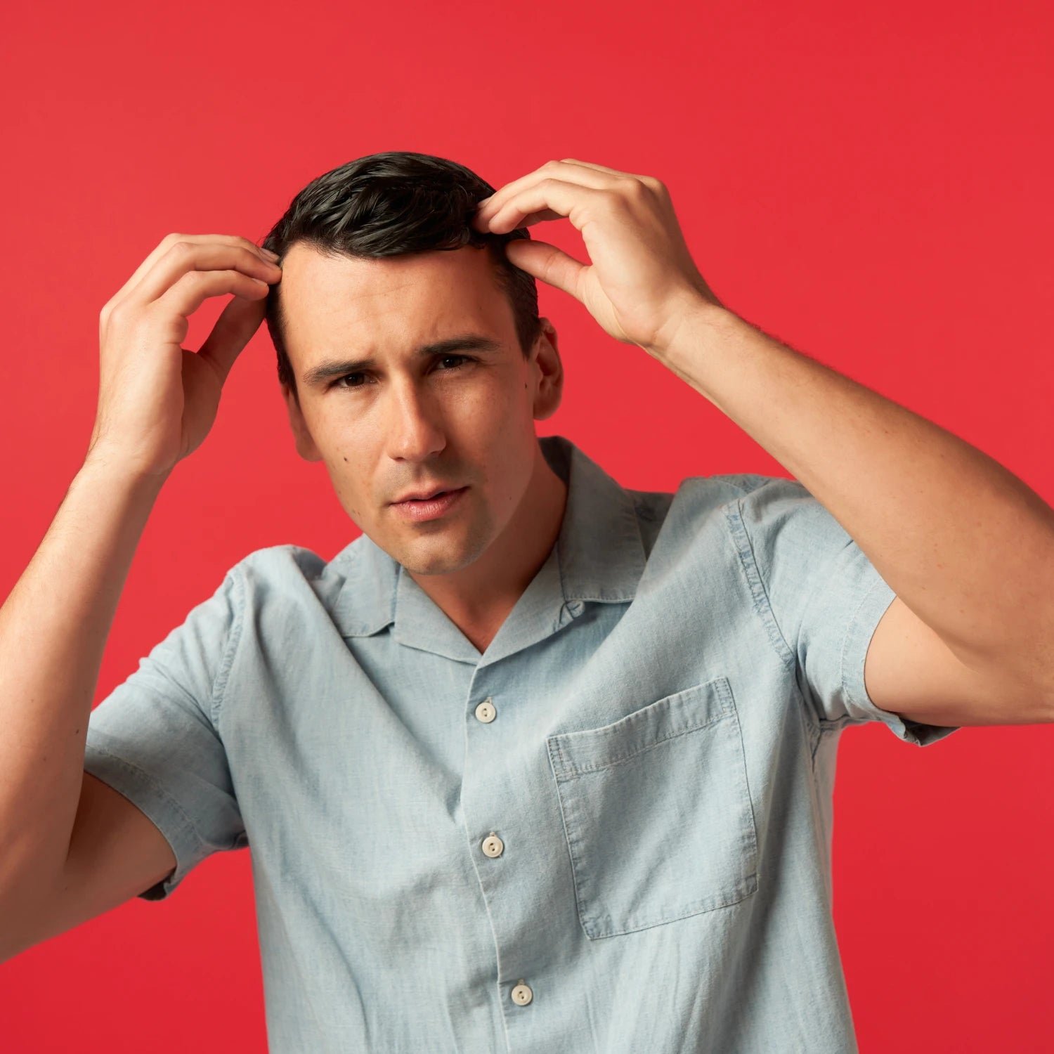 Image of a man holding his hair with pensive facial expression.
