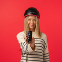Image of a woman wearing the Elite helmet device while holding the rechargeable battery pack.