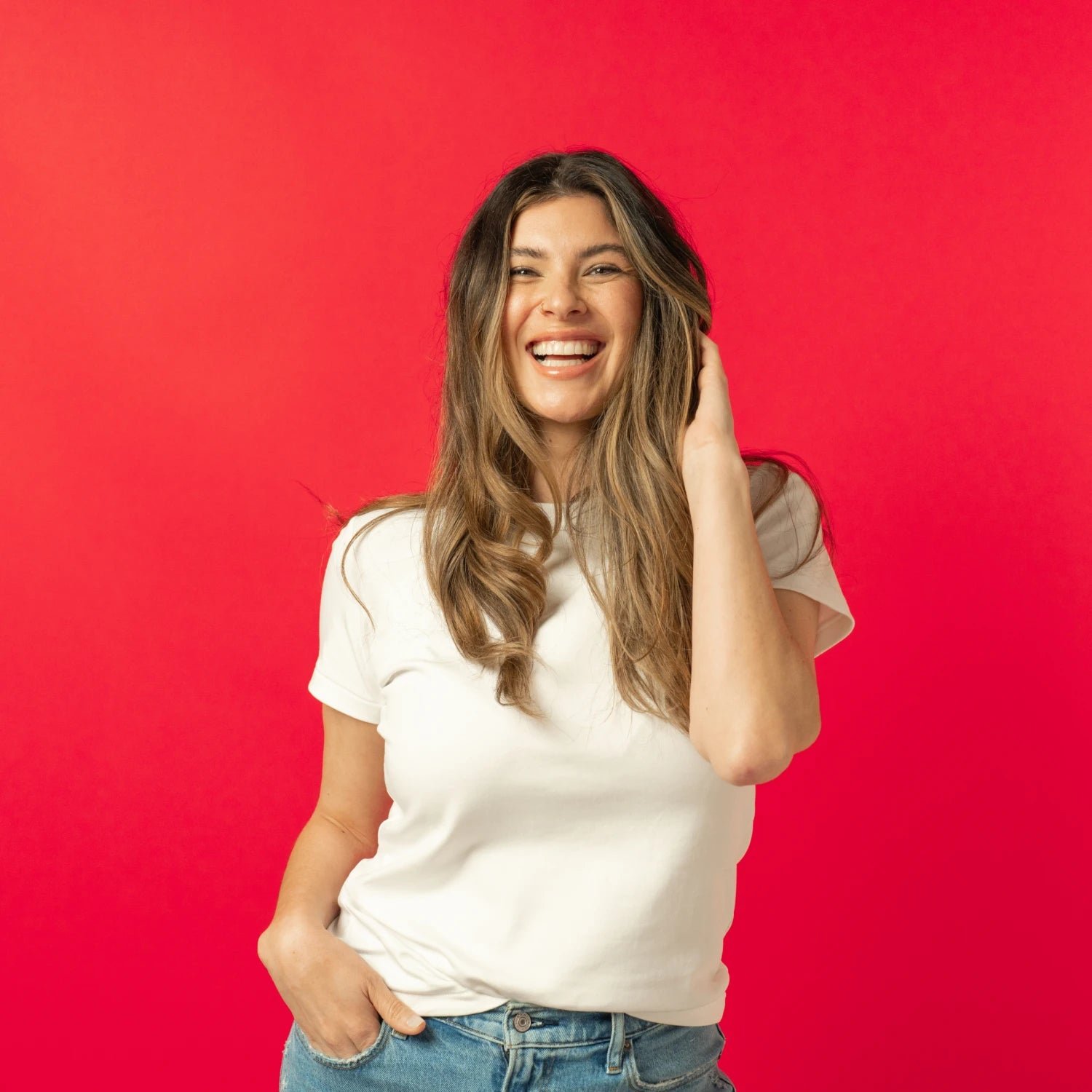 Image of a woman holding her hair with a happy facial expression.