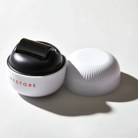 Image of the ScalpStim Derma Roller placed on top of a table with its cap beside it.