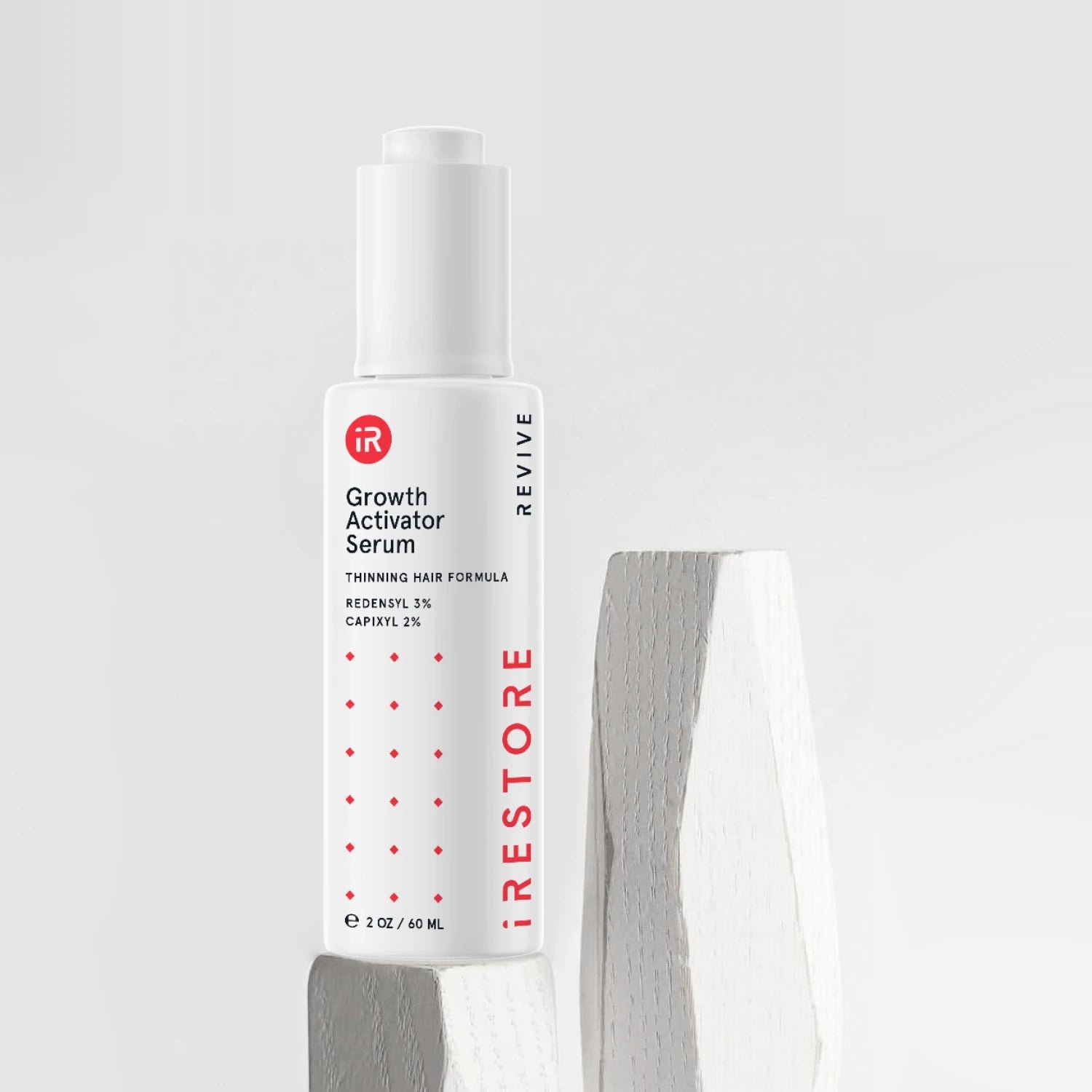 Image showing the Growth Activator Serum placed on top of a rock.