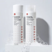 Image showing the Thickening Shampoo and Conditioner with bubbles around the bottle.
