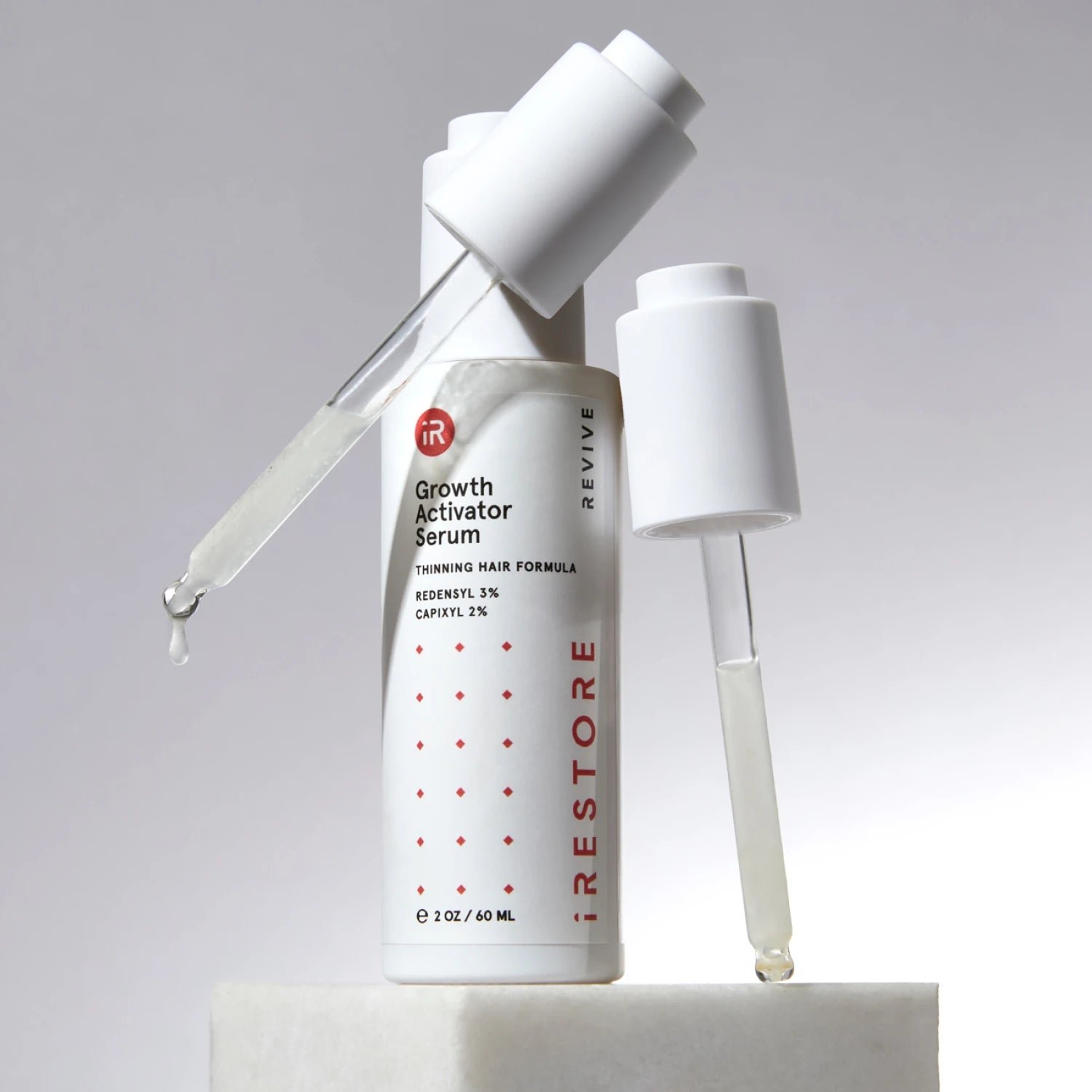 Image showing the Growth Activator Serum with two droppers beside it.