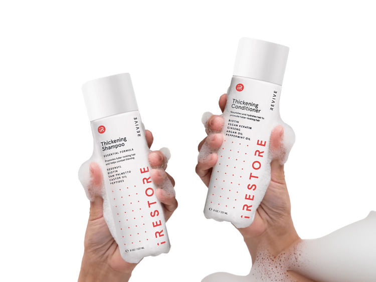 Left and holding thickening shampoo and right hand holding thickening conditioner.