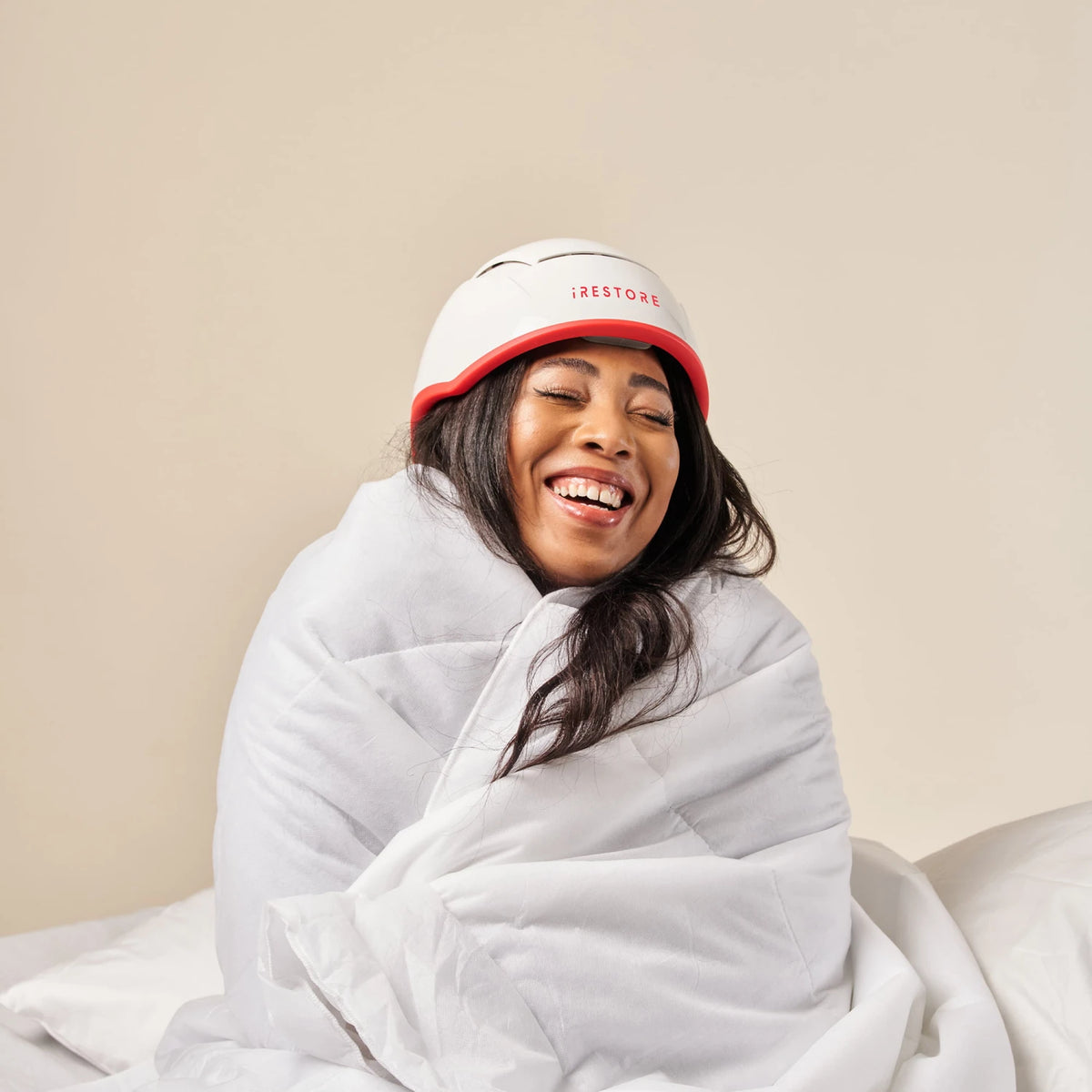 Image of a middle aged woman wearing the Professional hair device in her bed.