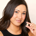 Image of a woman holding two tablets of the Advanced Hair Growth Formula.