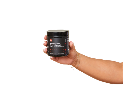 Image of a hand holding the jar of the Advanced Hair Growth Formula.