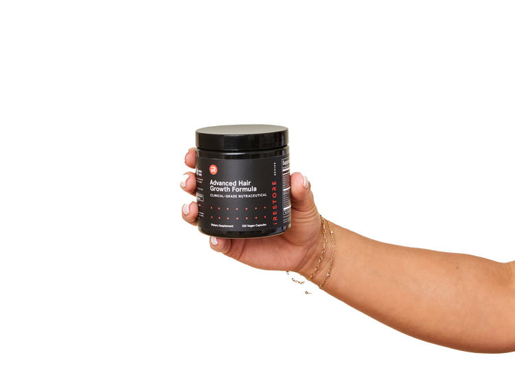 Image of a hand holding the jar of the Advanced Hair Growth Formula.