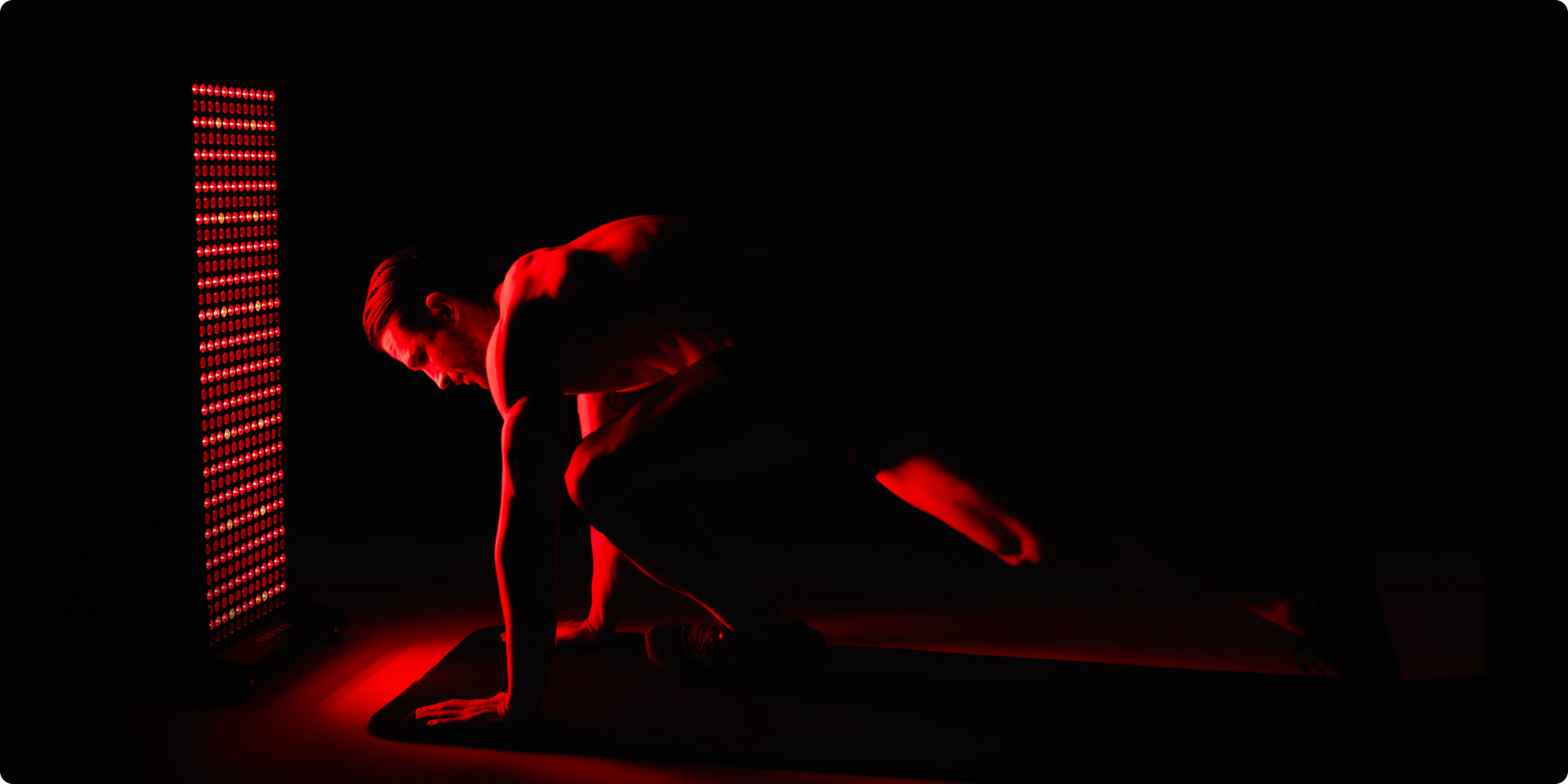 Person in a dark room with red lighting, standing in front of a led body panel