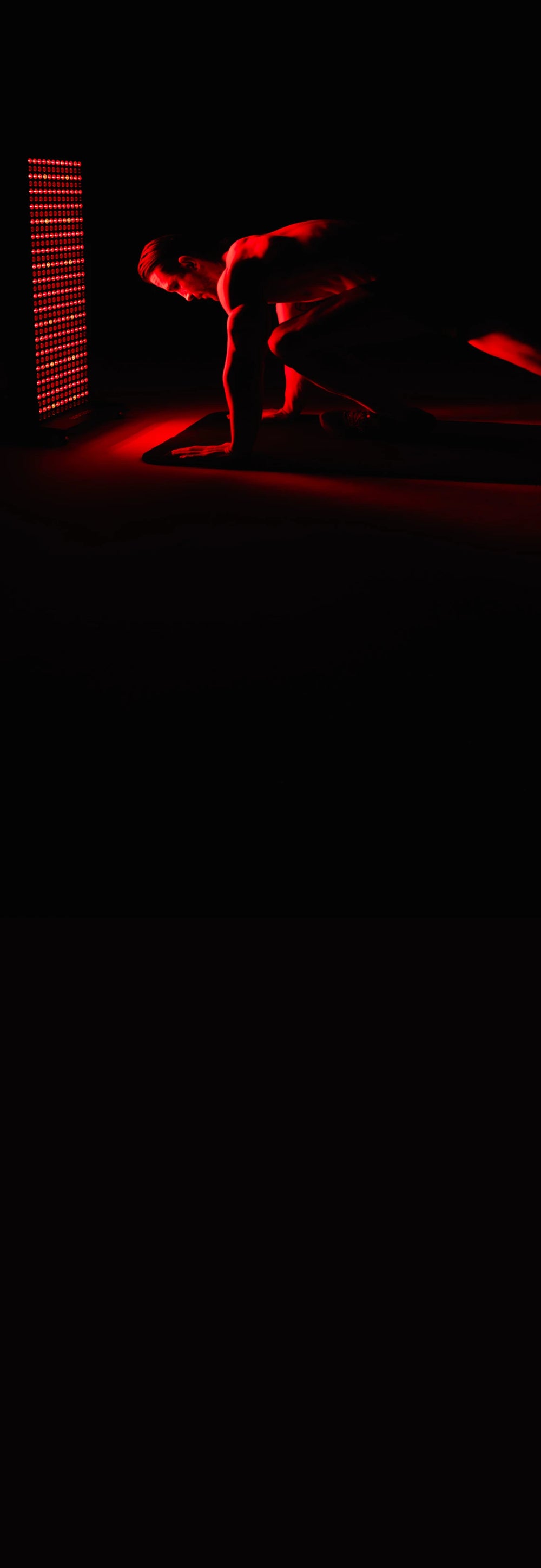 Person in a dark room with red lighting, standing in front of a led body panel