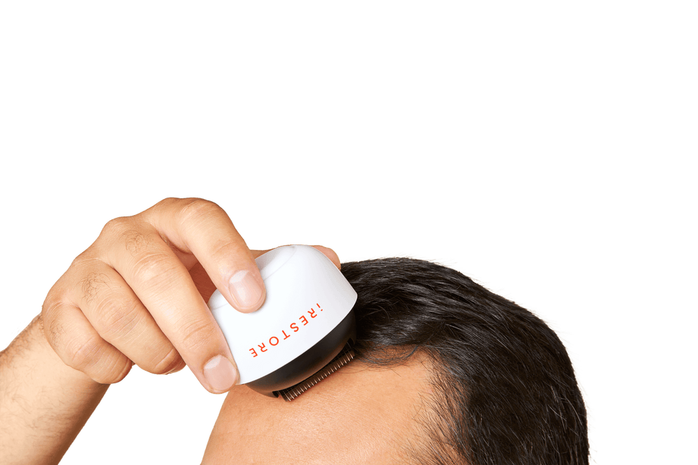 Close up shot image of a man rolling the derma roller in his scalp.