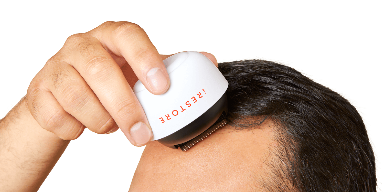 Close up shot image of a man rolling the derma roller in his scalp.
