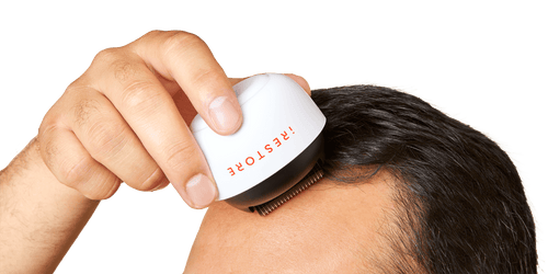 Close up shot image of a man rolling the derma roller in his scalp.