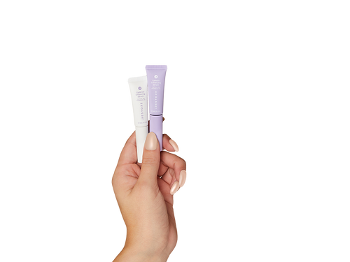 Hand holding eyelash enhancing serum and eyebrow enhancing serum