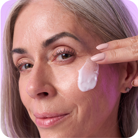 Mature woman rubbing anti-aging face serum on her face
