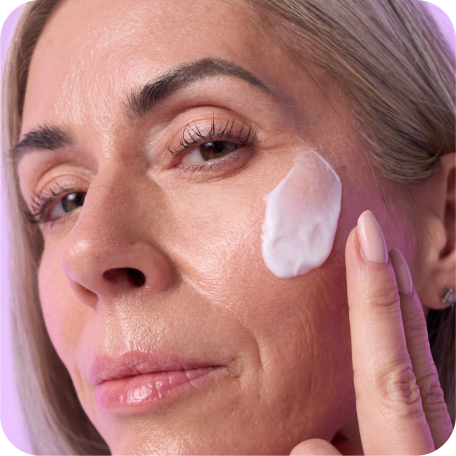 Mature woman rubbing anti-aging face serum on her face