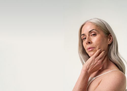 Mature woman brushing her cheek using her hand
