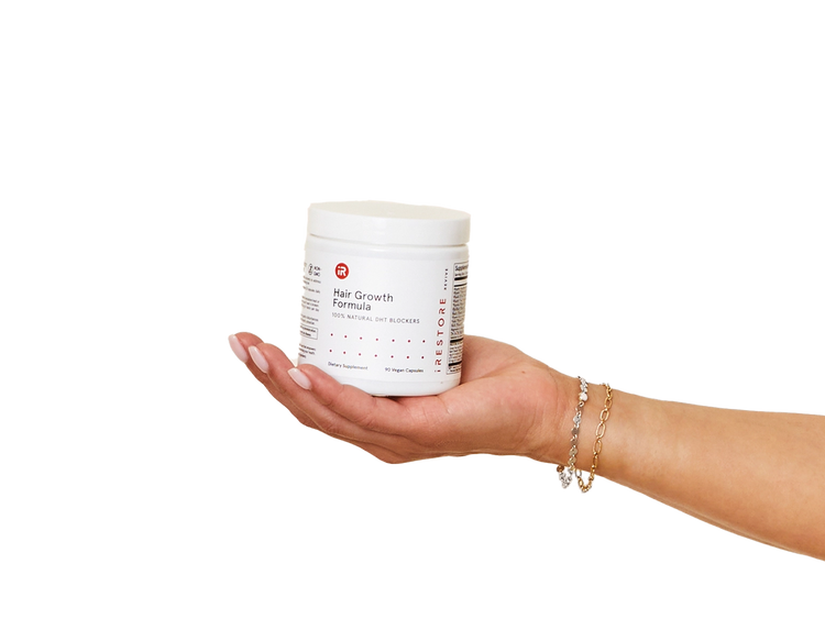 Close up shot of hand holding holding the Hair Growth Formula container