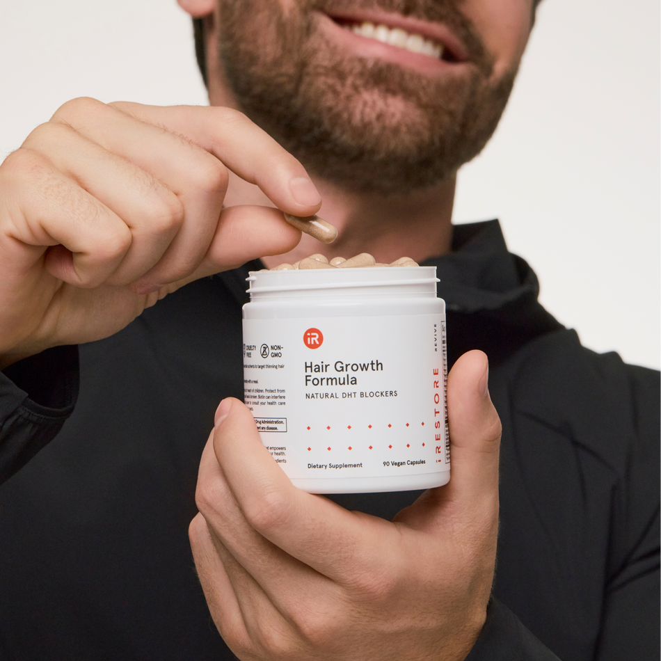 man taking out a tablet from hair growth formula bottle