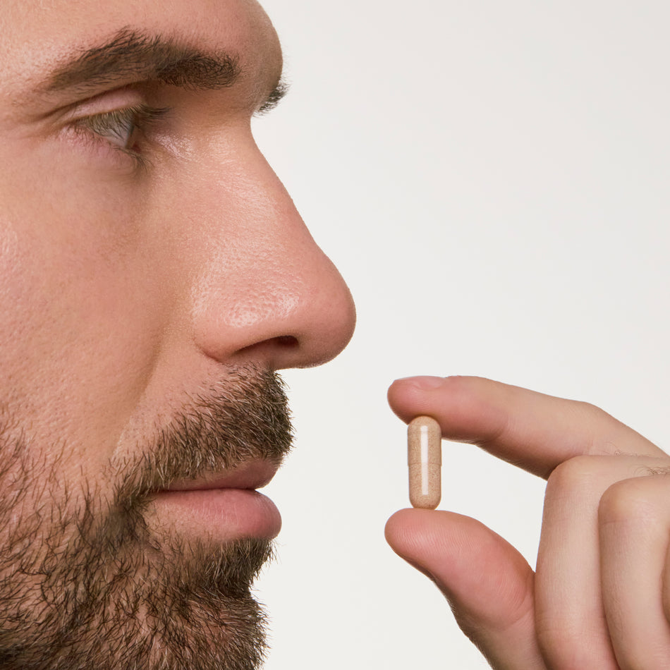man holding a pill near his mouth