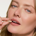 woman holding a pill near her mouth