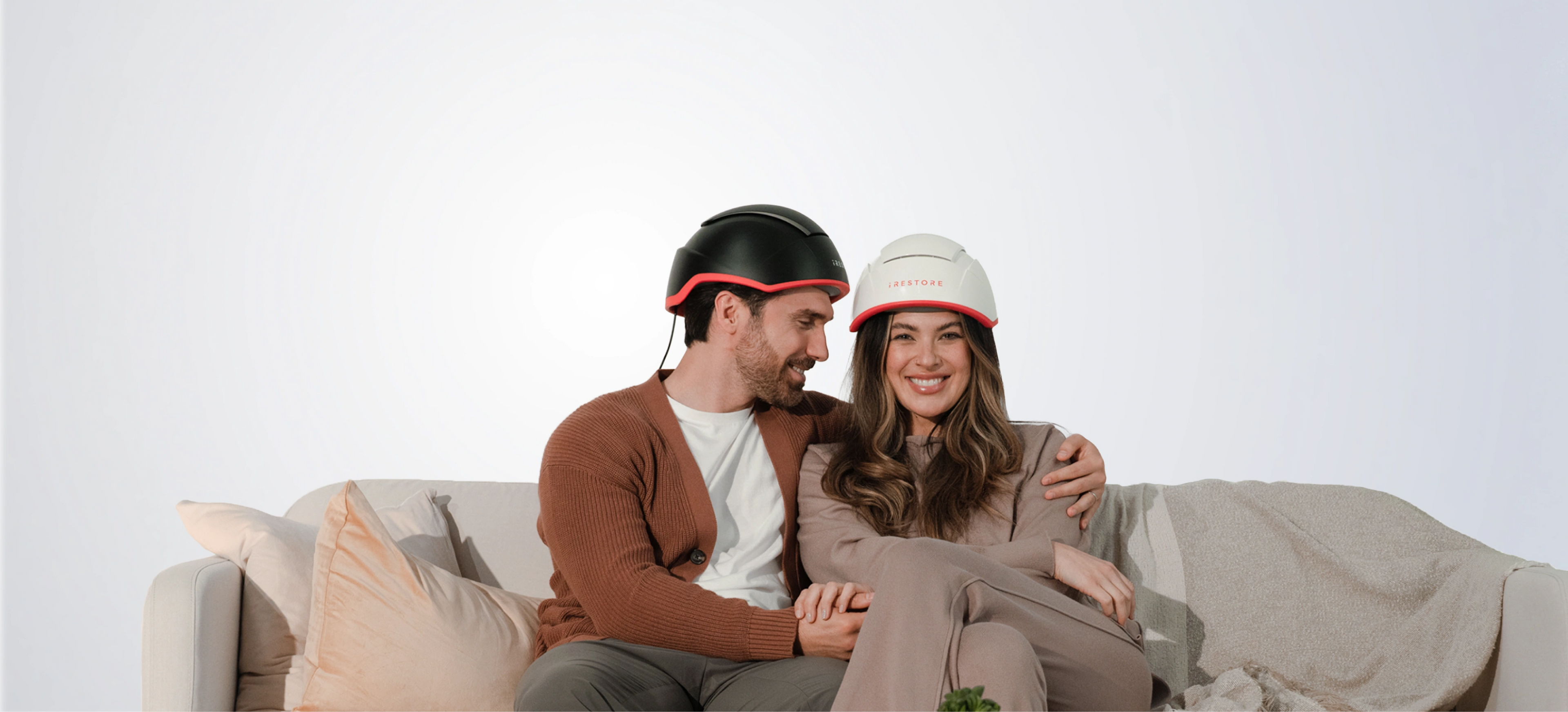 Couple wearing an iRESTORE Elite on a light gray background