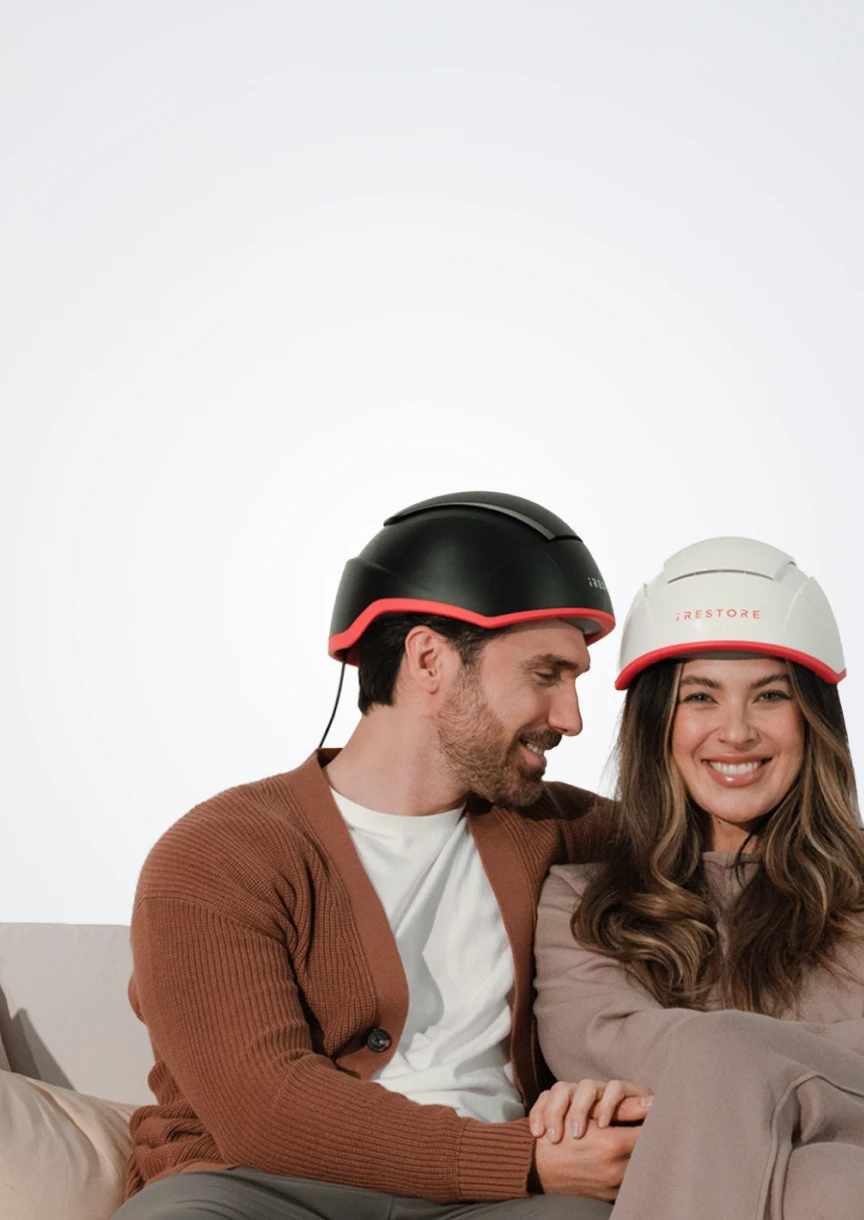 Couple wearing an iRESTORE Elite on a light gray background