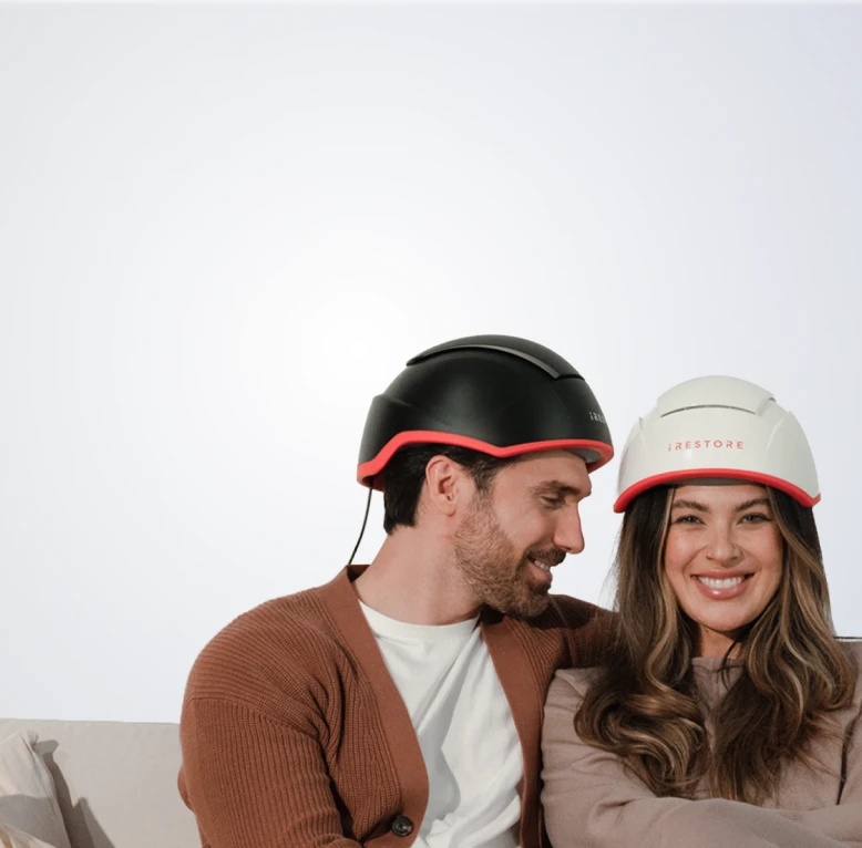 Couple wearing an iRESTORE Elite on a light gray background