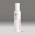 White bottle of light activated mist on a gray background