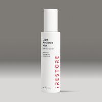 White bottle of light activated mist on a gray background