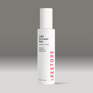 White bottle of light activated mist on a gray background