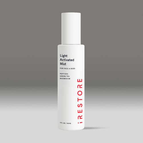 White bottle of light activated mist on a gray background