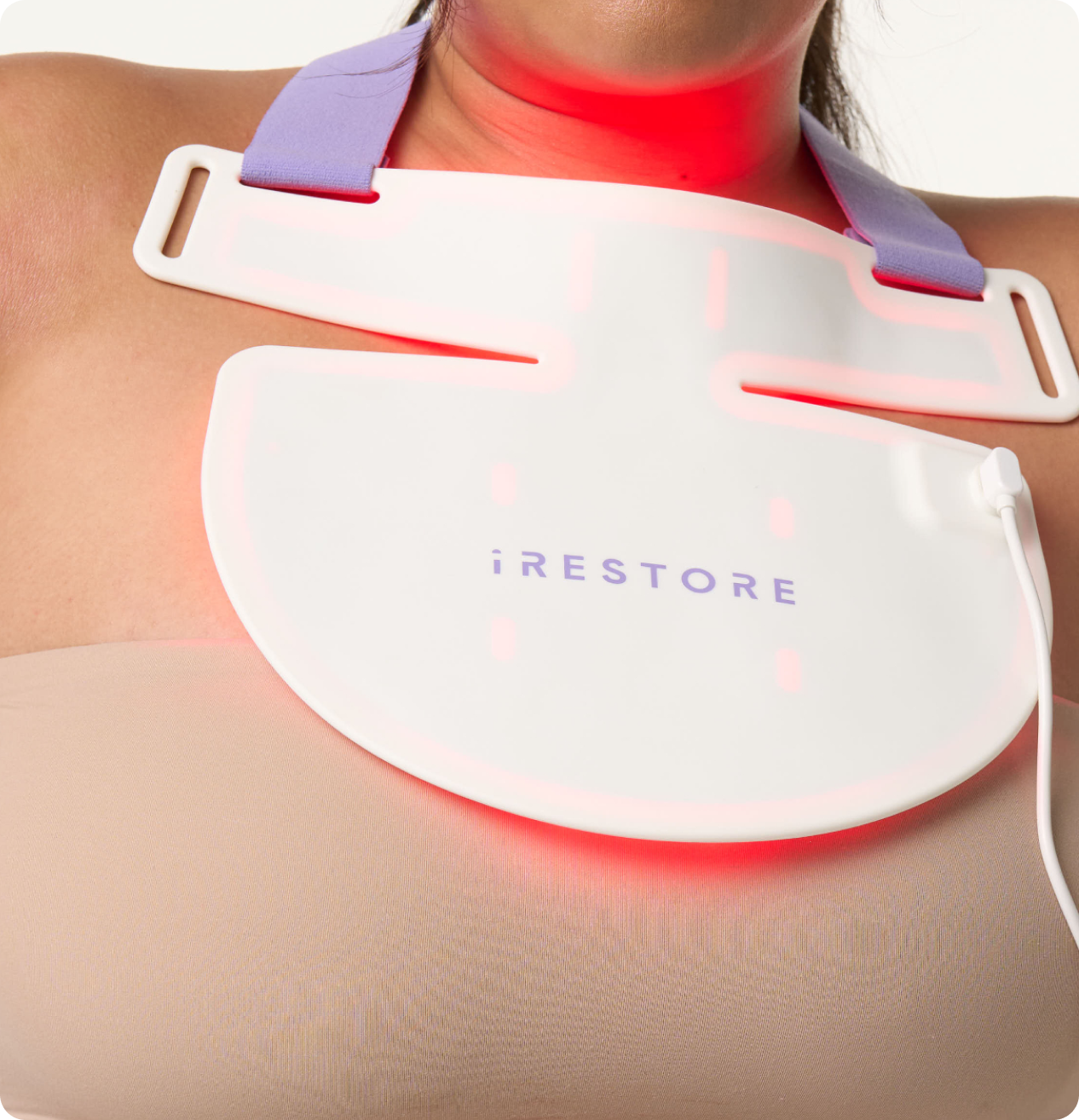 Close up shop of woman's neck whil wearing the iRESTORE LED neck and chest mask with red light turned on