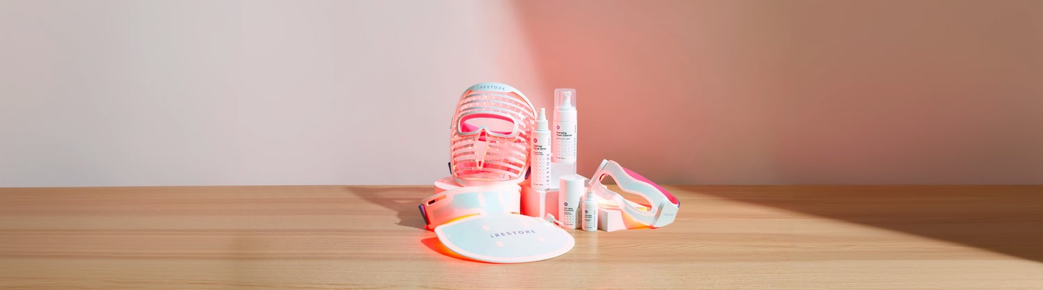 LED face mask, LED neck and chest mask, LED eye mask, Calming facial spray, Hydrating foam cleanser, Anti-aging face serum, and Anti-aging eye cream on top of a wooden table