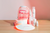 LED face mask, LED neck and chest mask, Calming facial spray, Hydrating foam cleanser, Anti-aging face serum, and Anti-aging eye cream on top of a wooden table