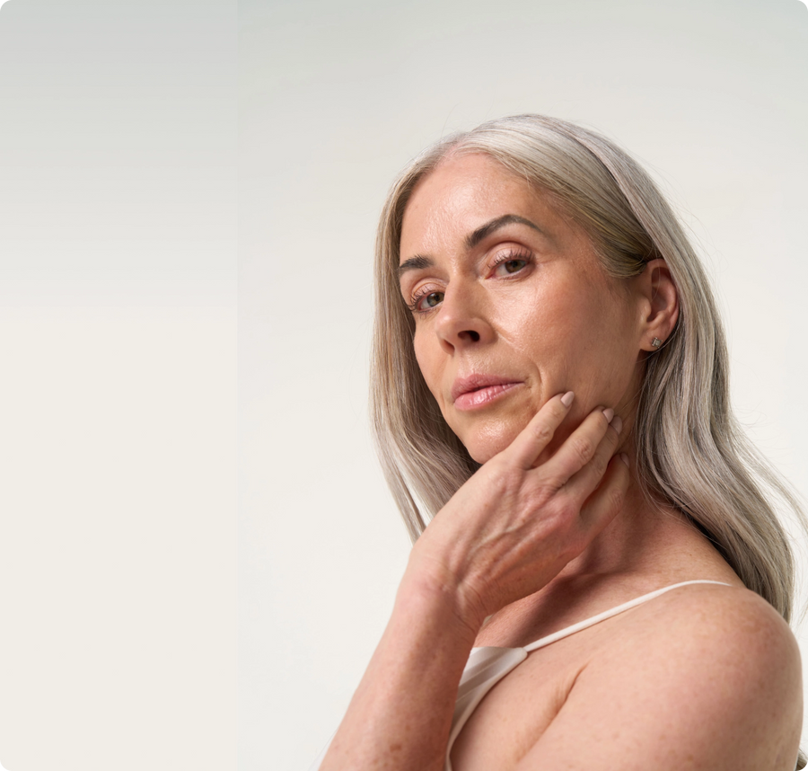 Mature woman brushing her cheek using her hand