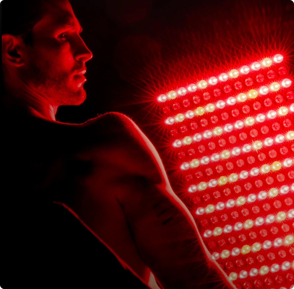 Person receiving red light therapy from a LED panel