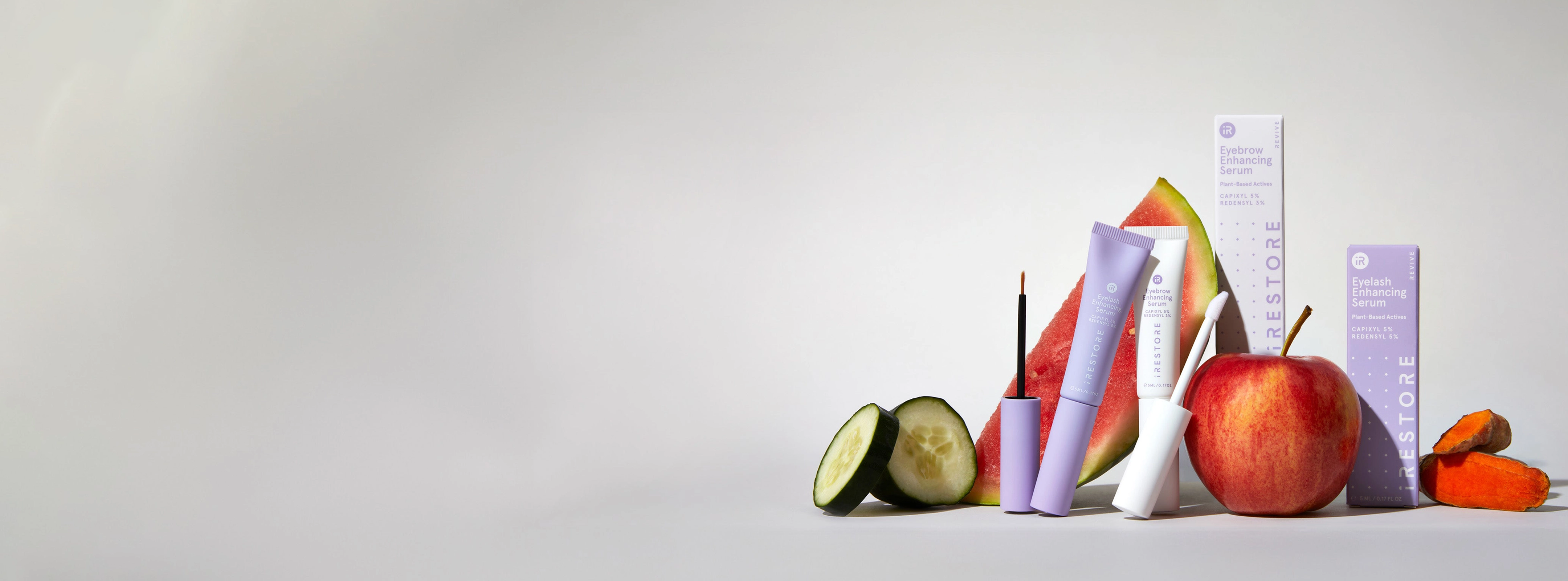 Image banner showing the Eye Care Line Products which includes the Eyebrow and Eyelash Enhancing Serum. Cucumbers, watermelon and apple is in the background.