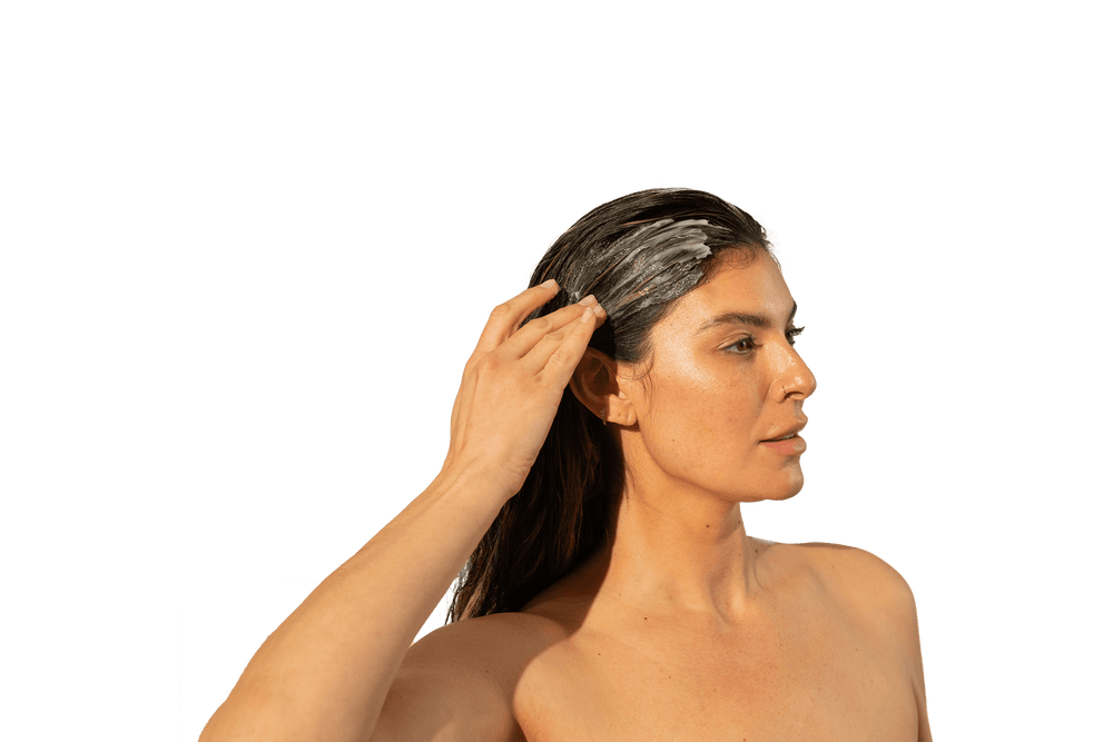 Image of a woman applying a Thickening Conditioner on her long hair.