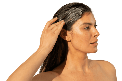 Image of a woman applying a Thickening Conditioner on her long hair.