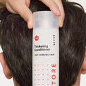 man holding a conditioner bottle behind his head