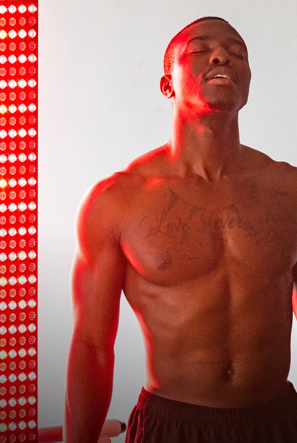 Man receiving red light therapy on a gray background